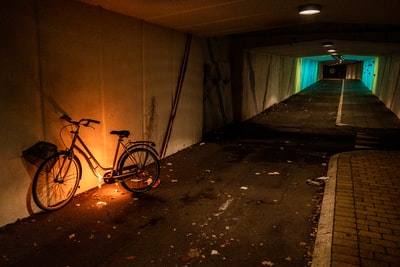 Stop at the white wall next to the black bike
